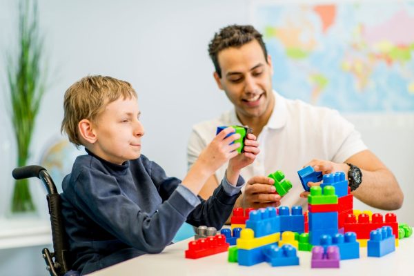 NDAG worker assisting a disabled young boy